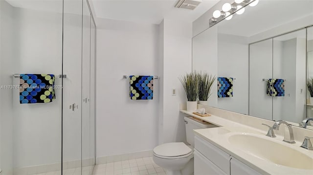 bathroom featuring vanity, toilet, and tile patterned flooring