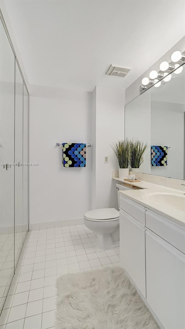 bathroom with walk in shower, tile patterned floors, toilet, and vanity