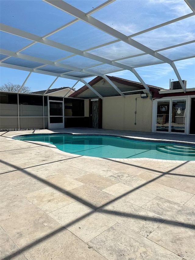 view of pool featuring cooling unit and a lanai