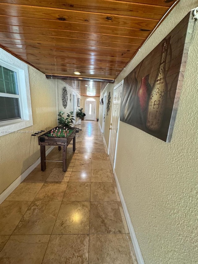 hallway with tile patterned flooring and wood ceiling