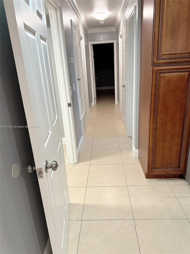 hallway featuring light tile patterned floors and ornamental molding