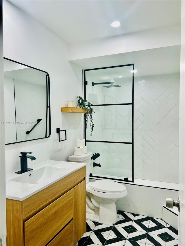 full bathroom featuring enclosed tub / shower combo, vanity, and toilet