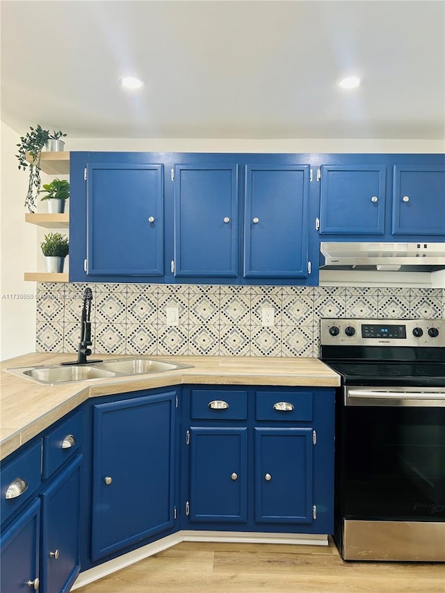 kitchen featuring blue cabinetry, sink, decorative backsplash, and electric stove