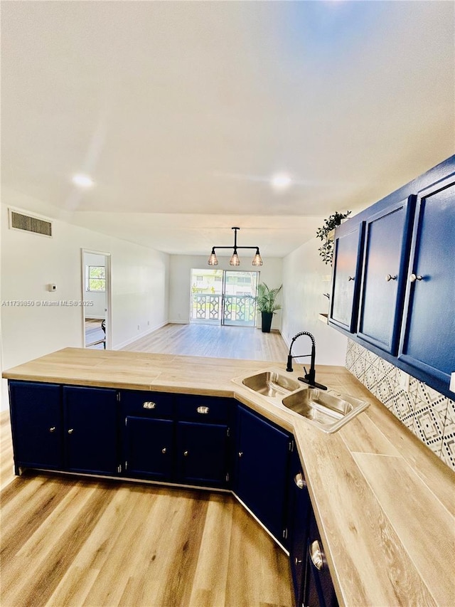 kitchen featuring butcher block counters, sink, and light wood-type flooring