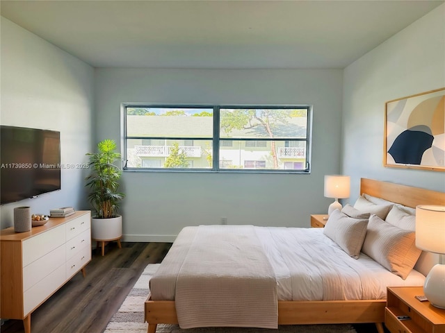 bedroom featuring multiple windows and dark hardwood / wood-style flooring