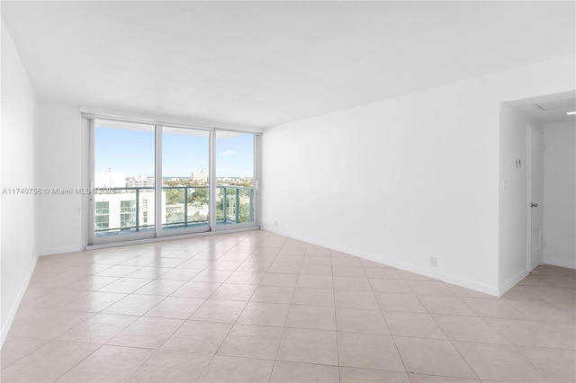 unfurnished room featuring light tile patterned floors and floor to ceiling windows