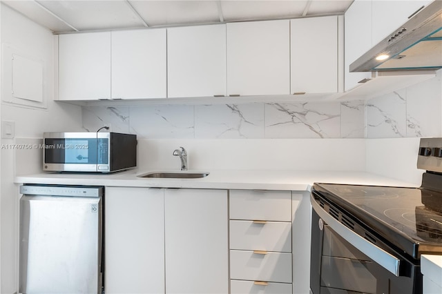 kitchen featuring sink, range hood, stainless steel appliances, tasteful backsplash, and white cabinets