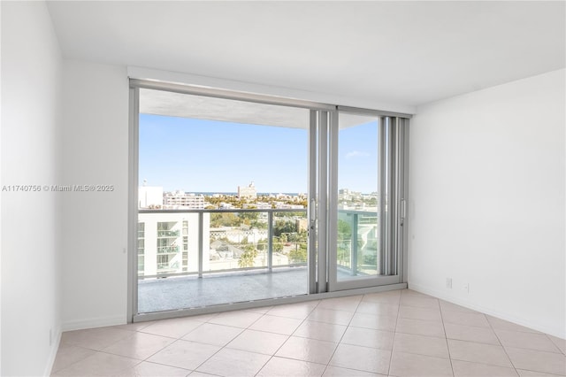 tiled empty room featuring floor to ceiling windows and a healthy amount of sunlight