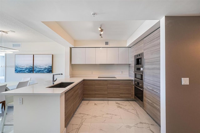 kitchen with sink, white cabinetry, black electric stovetop, a kitchen bar, and kitchen peninsula