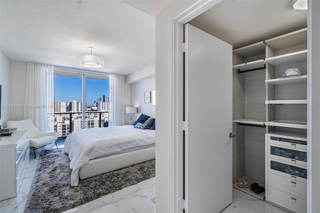 bedroom with expansive windows and a textured ceiling