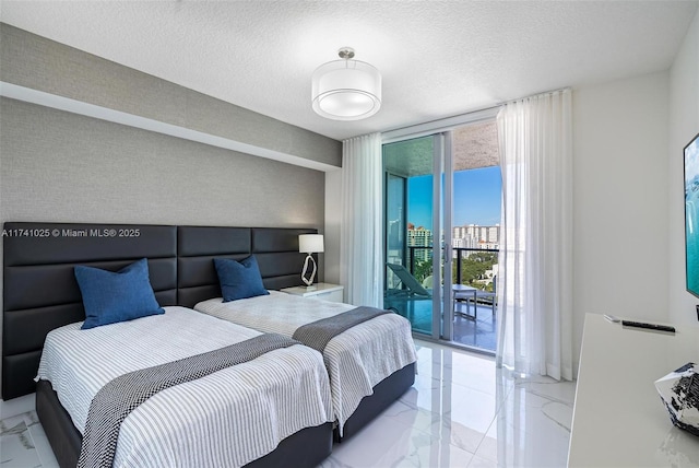 bedroom with access to exterior, a wall of windows, and a textured ceiling