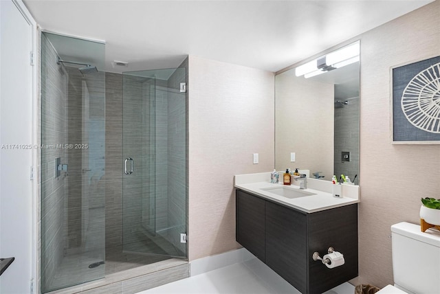 bathroom featuring vanity, an enclosed shower, and toilet