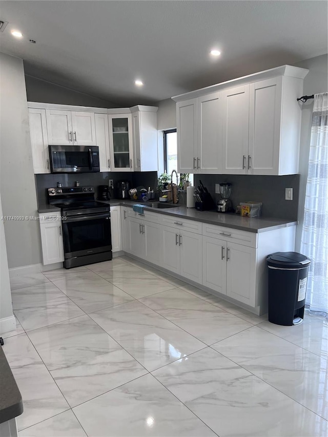 kitchen with tasteful backsplash, black range with electric stovetop, sink, and white cabinets