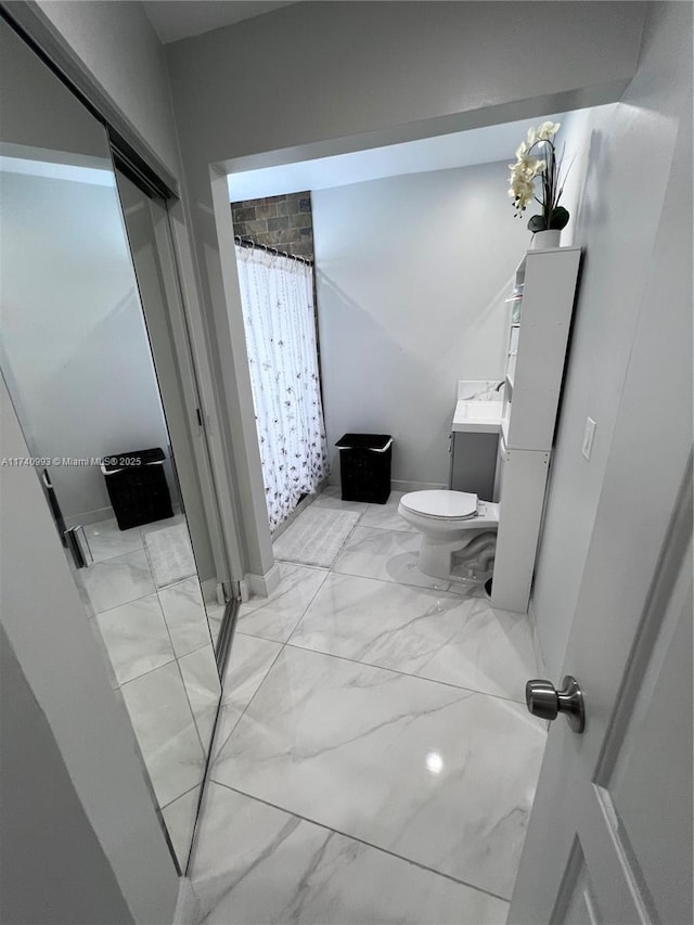 bathroom featuring vanity, toilet, and curtained shower