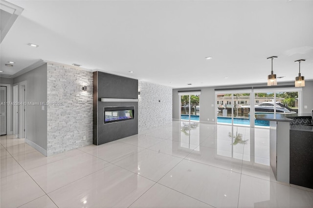 2816 NE 24th Pl, Fort Lauderdale, FL 33305 - unfurnished living room featuring light tile patterned flooring, a fireplace, crown molding, recessed lighting, and an accent wall