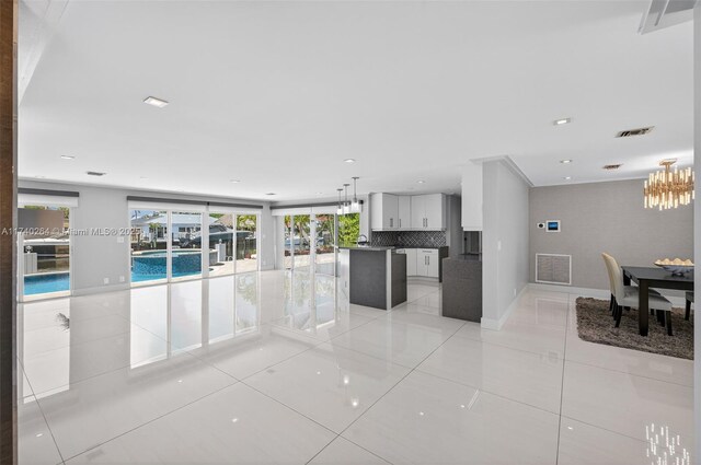 2816 NE 24th Pl, Fort Lauderdale, FL 33305 - unfurnished living room with light tile patterned flooring, a chandelier, and recessed lighting