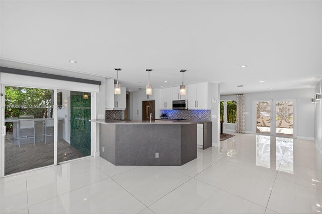 2816 NE 24th Pl, Fort Lauderdale, FL 33305 - kitchen with stainless steel appliances, light tile patterned floors, decorative backsplash, white cabinetry, and recessed lighting