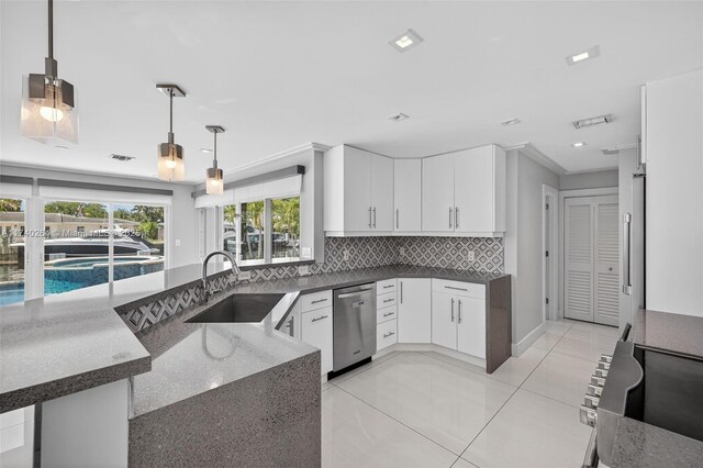 2816 NE 24th Pl, Fort Lauderdale, FL 33305 - kitchen with dishwasher, dark stone counters, decorative backsplash, white cabinets, and decorative light fixtures