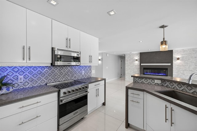2816 NE 24th Pl, Fort Lauderdale, FL 33305 - kitchen with stainless steel appliances, dark countertops, decorative backsplash, light tile patterned floors, and decorative light fixtures