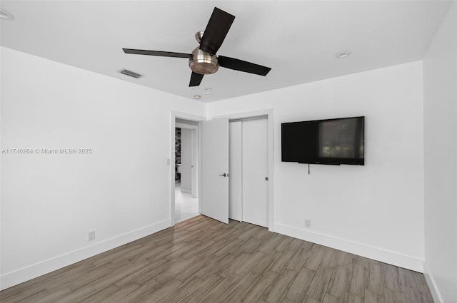 2816 NE 24th Pl, Fort Lauderdale, FL 33305 - unfurnished bedroom featuring wood finished floors, a closet, and a ceiling fan