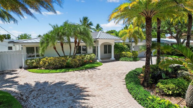 2816 NE 24th Pl, Fort Lauderdale, FL 33305 - single story home featuring a standing seam roof, stucco siding, a metal roof, and driveway