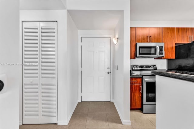 kitchen with light tile patterned flooring and appliances with stainless steel finishes