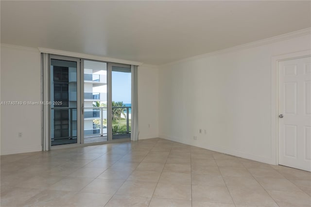 spare room with light tile patterned floors, ornamental molding, and expansive windows