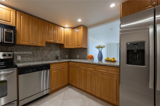 kitchen featuring light tile patterned flooring, appliances with stainless steel finishes, sink, backsplash, and light stone countertops