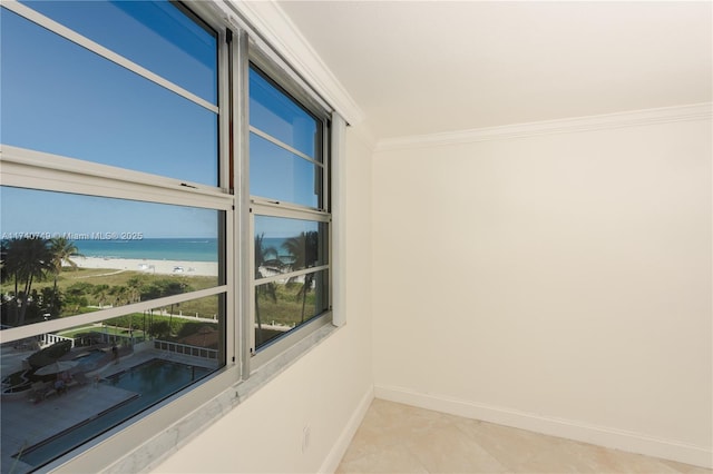 tiled empty room featuring crown molding, a beach view, and a water view