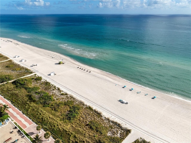 drone / aerial view featuring a beach view and a water view