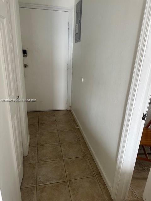 hallway with tile patterned floors and electric panel