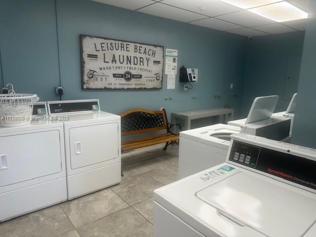 clothes washing area with light tile patterned floors and independent washer and dryer