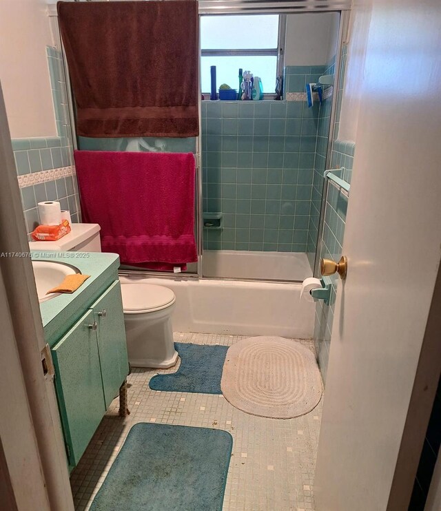 17090 NE 14th Ave Unit 314, Miami, FL 33162 - bathroom with tile walls, tile patterned floors, toilet, bath / shower combo with glass door, and vanity
