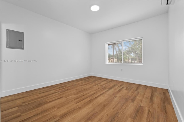 spare room featuring hardwood / wood-style flooring and electric panel