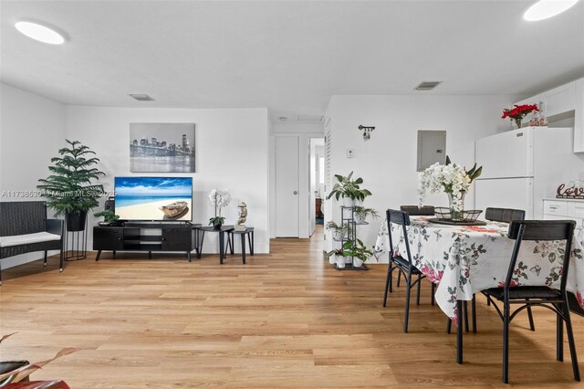 dining area featuring electric panel and light hardwood / wood-style flooring