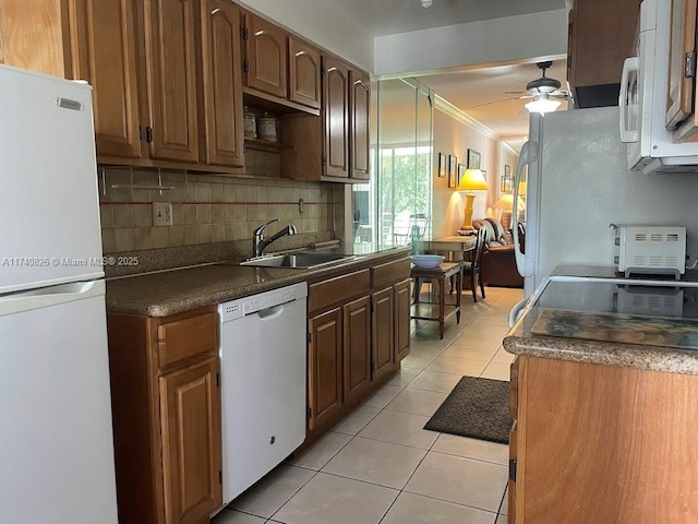 kitchen with light tile patterned floors, white appliances, sink, backsplash, and ornamental molding