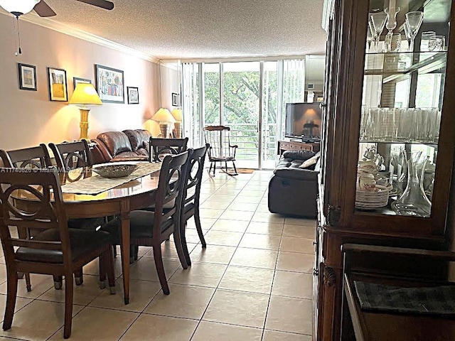 tiled dining space featuring crown molding, ceiling fan, expansive windows, and a textured ceiling