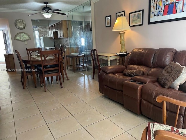 living room with light tile patterned floors, ornamental molding, and ceiling fan