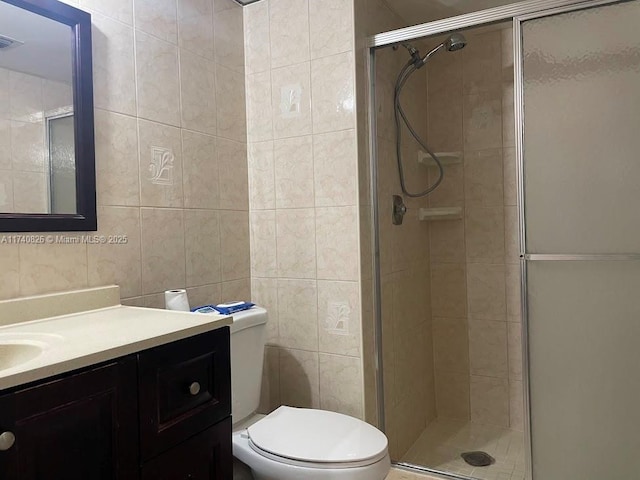 bathroom with vanity, tile walls, an enclosed shower, and toilet