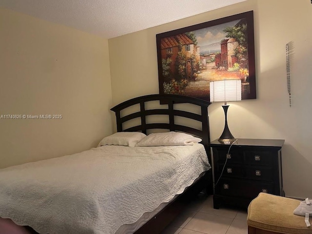 bedroom with light tile patterned flooring and a textured ceiling