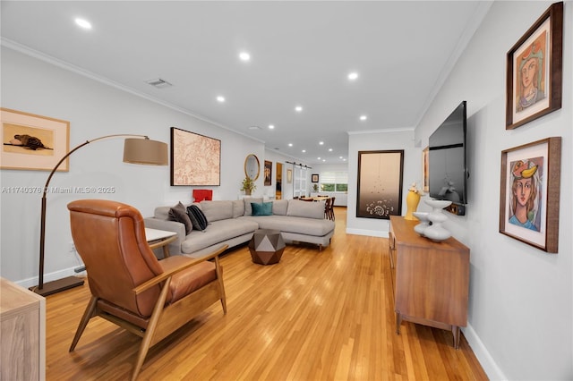 living room featuring ornamental molding and light hardwood / wood-style floors