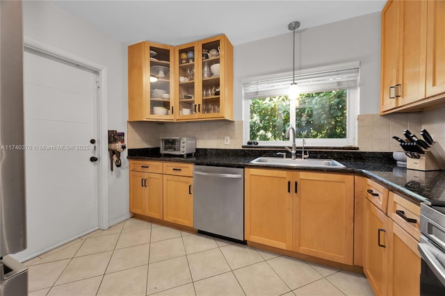 kitchen featuring sink, stainless steel dishwasher, pendant lighting, dark stone counters, and decorative backsplash