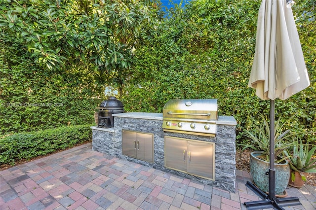 view of patio / terrace featuring exterior kitchen and a grill