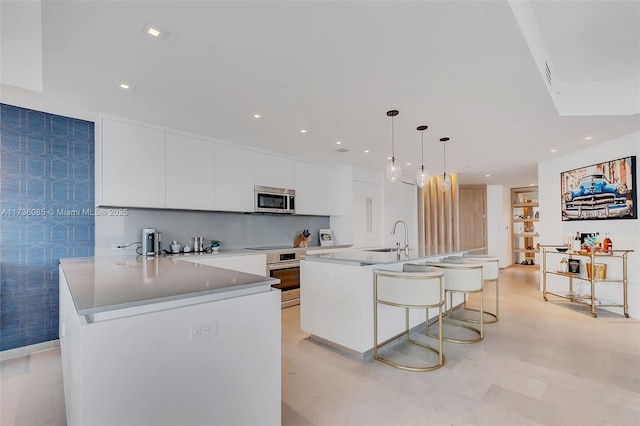 68 SE 6th St Unit 3911, Miami, FL 33131 - kitchen featuring sink, a breakfast bar area, white cabinets, hanging light fixtures, and stainless steel appliances