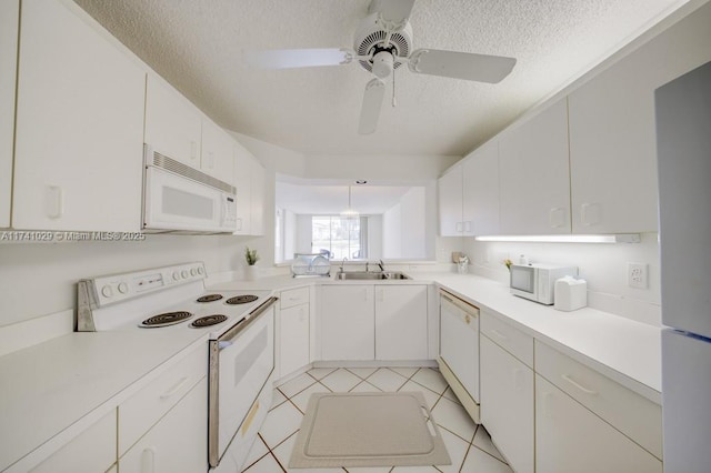 kitchen featuring white cabinetry, sink, white appliances, kitchen peninsula, and a textured ceiling