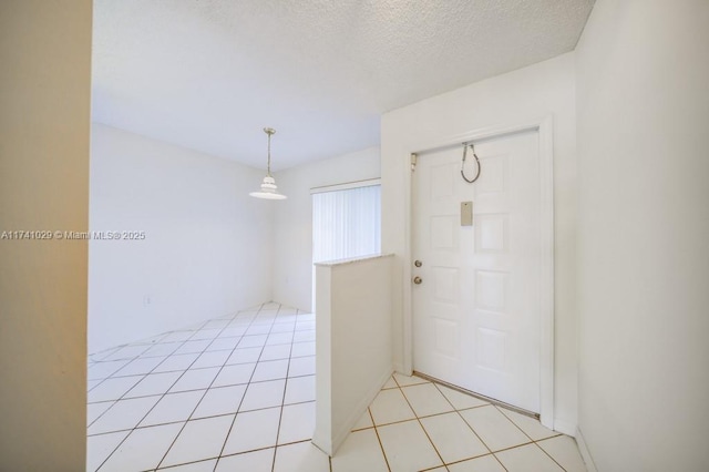 entryway with a textured ceiling and light tile patterned floors