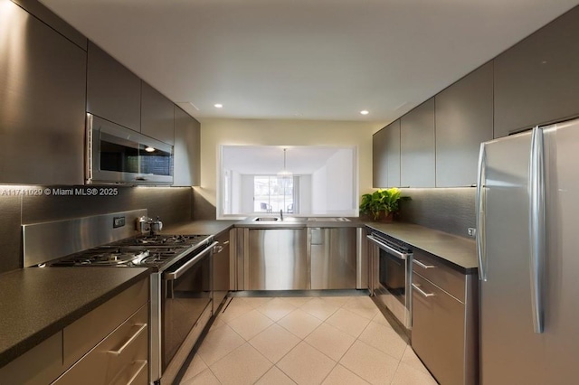 kitchen featuring backsplash, light tile patterned floors, stainless steel appliances, and sink
