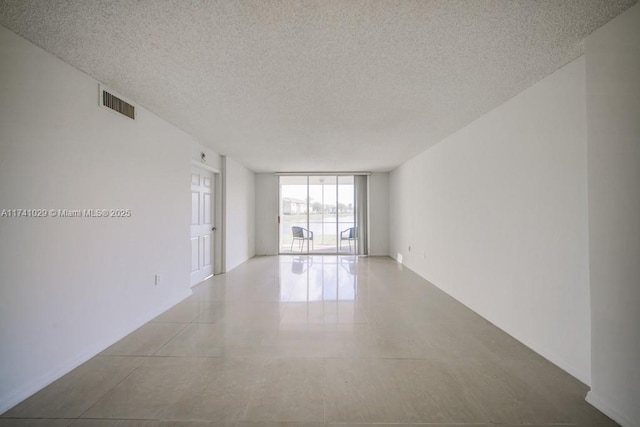 empty room with a wall of windows and a textured ceiling