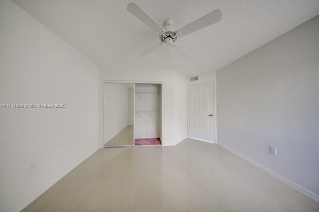 unfurnished bedroom featuring ceiling fan, a closet, and a textured ceiling