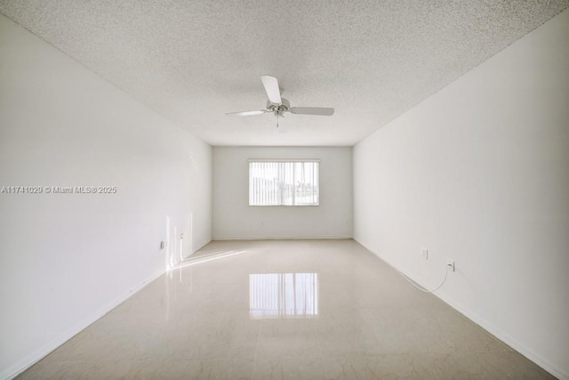 unfurnished room with ceiling fan and a textured ceiling